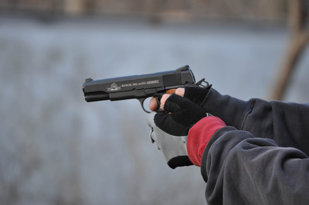 1911 .45 Caliber Hand Gun Aiming for a Target