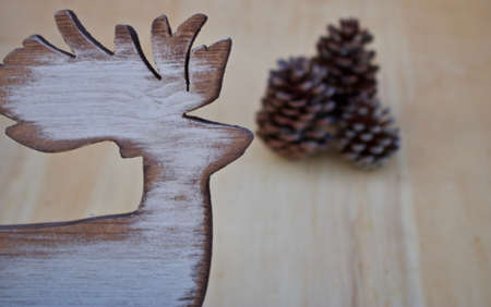 wooden elk-shaped and pine cones Christmas concept on wooden tableの写真素材
