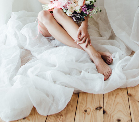 beautiful wedding bouquet lies on the lap of a girlの写真素材