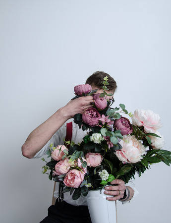 the guy is holding a bucket of flowers in his handsの写真素材