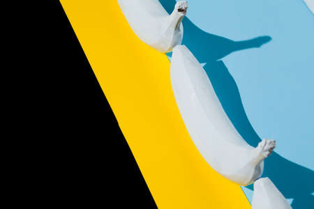 White banana on black and blue and yellow background