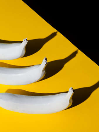 White banana on yellow and black backgroundの写真素材