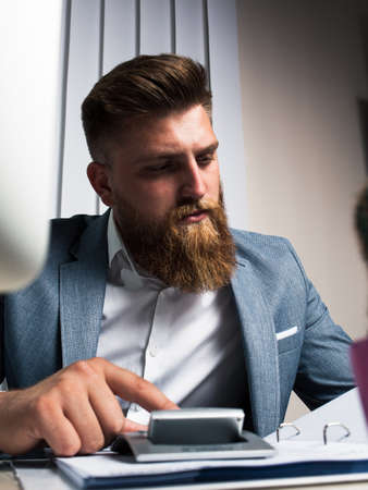 Businessman in office late night work calculatingの写真素材