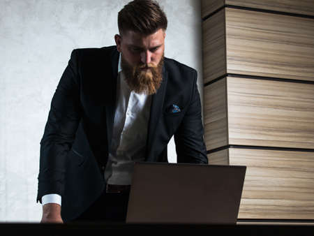 Young bearded businessman in office late night workの写真素材