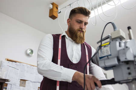 Young bearded tailor working on new cloting design