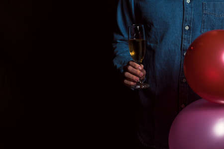 Young man in denim shirt hold champagne and balloonsの写真素材