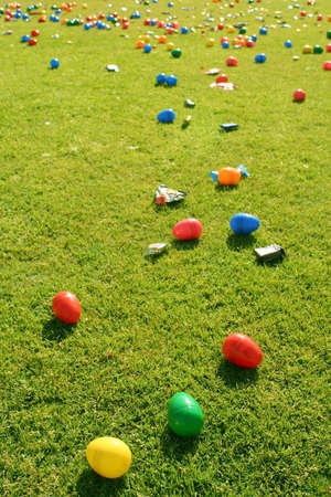 Many Easter Eggs and small candies laid out on grass ready for Children to come and hunt them.の写真素材