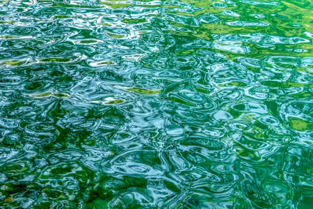 Green ripples on a river in Slovenia