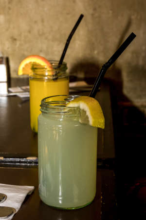Canning jars with lemonade and orange juice with fruit slices and straws in a restaurant in Tel Aviv, Israelの写真素材