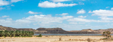 Panorama of Negev Arava Desert scene with mountains, palms trees and solar panels field in southern Israelの写真素材