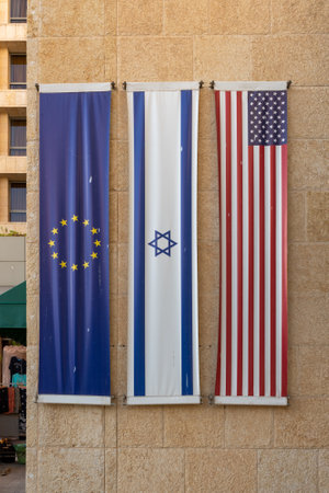 The European Union Flag, Israel flag and United States of America flag hanging vertically on a building in Jerusalem, Israelの写真素材