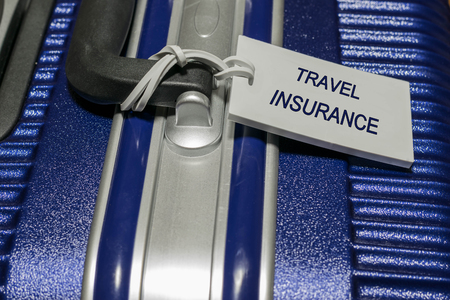 Travel insurance luggage tag tied to a suitcaseの写真素材