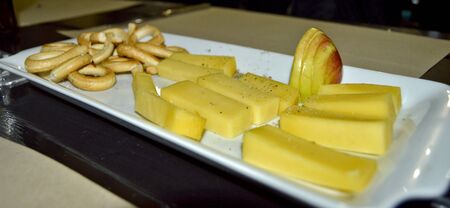 Stock photo of cheese and fruit platter, with thick cheese pieces, apple slices and small pretzelsの写真素材