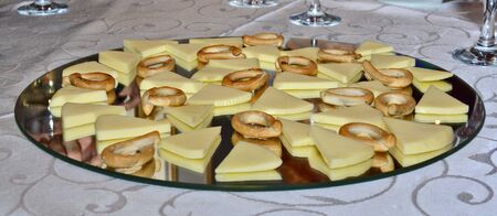 Tasty looking cheese arrangement on mirror platter, tasting cheeses paired with tiny pretzels on nice plating, organic and freshの写真素材