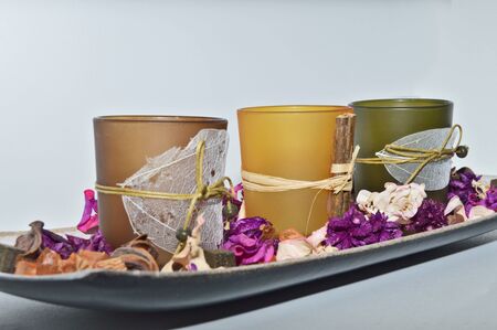 Close up shot of interior design idea, aroma therapy candles and potpourri dried leaves setting on white background, autumn colors like orange and purple make great designの写真素材