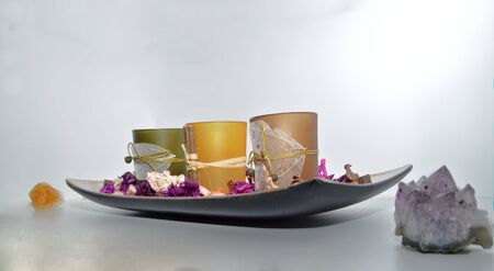 Orange and purple design decoration, potpourri platter with autumn color motif, scented candles and dried flowers next to salt crystals for relaxation, therapeutic design ideasの写真素材