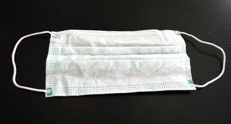 Medical face mask, closeup of a surgical mask on a dark background, virus protection during pandemicの写真素材