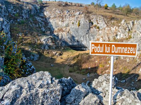 A sign indicating God's Bridge (Podul lui Dumnezeu), a natural bridge created by the colapse of a cave, a famous tourist attraction in Ponoarele, Romania (taken on 10/26/2019)の写真素材