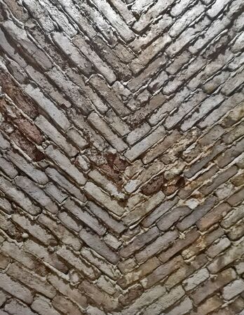 A vertical background with stone bricks in a downward facing v shape, brick wall textureの写真素材