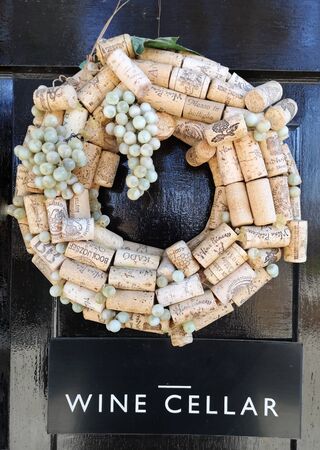 A decorative cork wreath with plastic grapes, creative use of old wine corks made into an ornament for the entrance to a wine cellar, great idea for wine loversの写真素材
