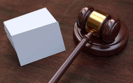 Judge, wooden gavel on the brown wooden background with white, blank business cards. Mockupの写真素材