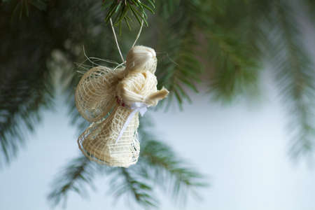 Christmas angel on christmas tree branch, lights hanging in a treeの写真素材