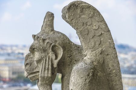 Gargoyle statue with paris aerial view in the background from Notre-dameの写真素材