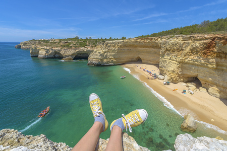 Tourist enjoying a beach view from a cliff in Algarve, Portugalの写真素材