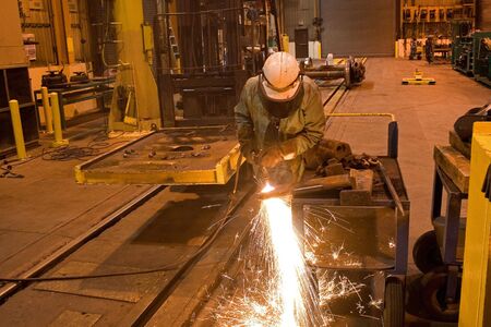 Railroad worker cutting steel with cutting torch.
