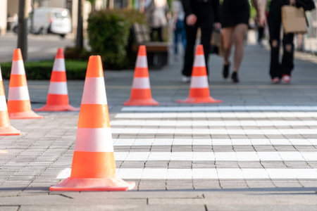 Orange traffics cones and new marking of pedestrian crossing in cityの写真素材