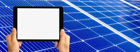 Digital tablet with blank screen in hands on background of blue solar panel.