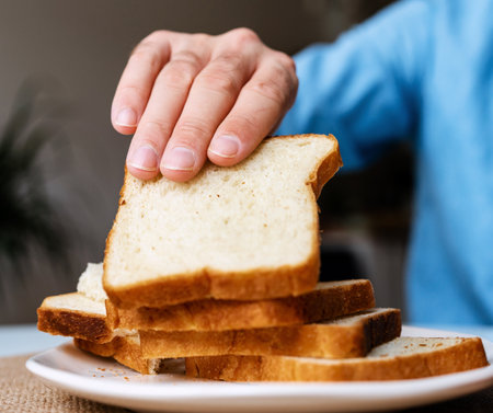 Male hand takes a slice of bread for toast.