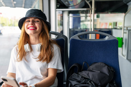 Joyful woman traveling around the city by bus. Passenger and public transportation in the city.の写真素材