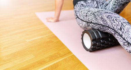 Reducing muscle pain after hard sports training. Warm up and cool down exercise with foam roller.