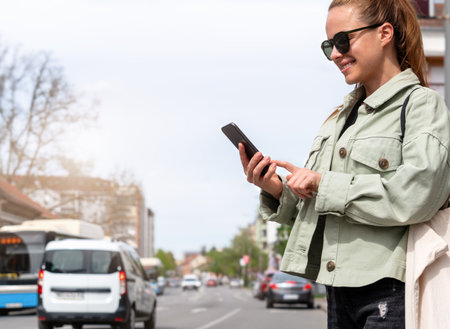 Mobility as a service. Urban woman searches rental car, rental transport using her smart phone.の写真素材