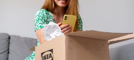 Woman at home  unpacking delivery from an Ikea online store and photographing purchase:: Serbia, Novi Sad - 04.02.2024のeditorial素材