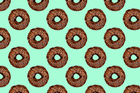 Creative pattern of chocolate donuts with holes on a mint background.の写真素材