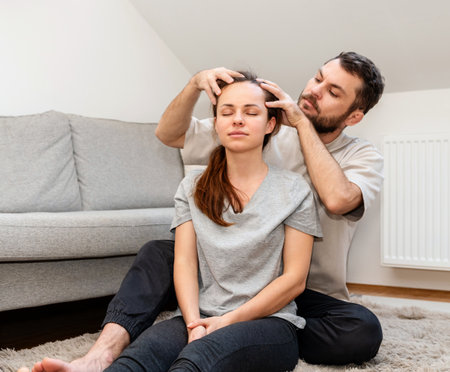 Care and comfort in family relationship. Man giving head massage to womanの写真素材