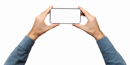 Isolated male's hands with blue sleeves holds mobile phone with empty screen and black frame.