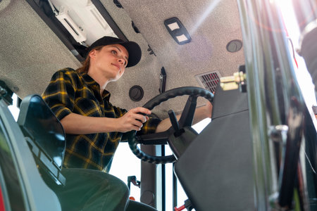 Woman working on a farm as a tractor driverの写真素材