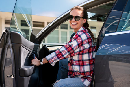 Portrait of a happy woman in her new car at a car dealership. Car rental concept. Confident female driver.の写真素材