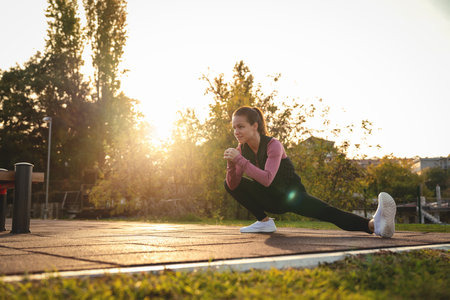 Caucasian woman doing stretching exercises during an outdoor workout.