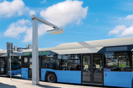 Pantograph charging electric buses station in city in front of summer blur sky. Zero-emission vehicles.の写真素材