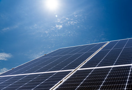 Solar energy plant on background of blue sky. Diagonal low view of blue solar panel.