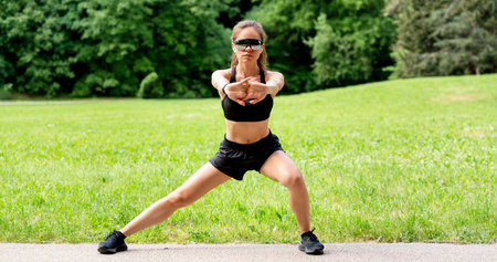 Focused fit woman in sportswear doing outdoor workout in city park