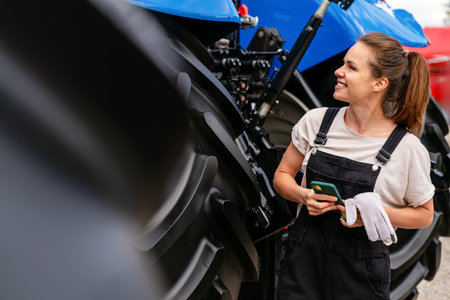 Female technician next to agricultural machineryの写真素材