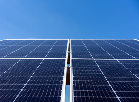 Low angle view of modern industrial solar panel against clean blue sky background