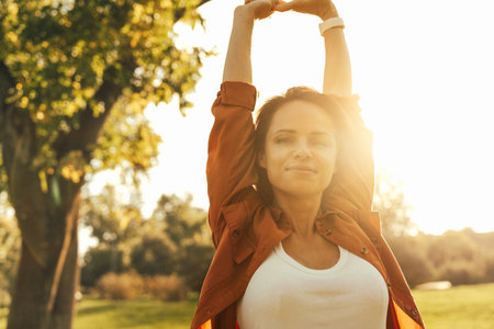 Happy woman  with raised arms enjoying nature and wellbeingの写真素材