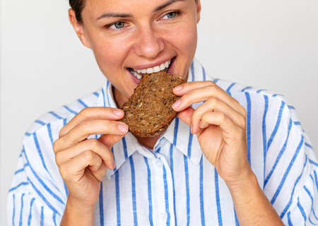 Closeup photo of woman eating grainy rye bread