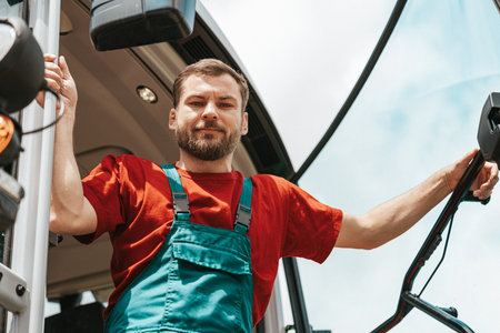 Low angle portrait of tractor driver outdoors in summer.